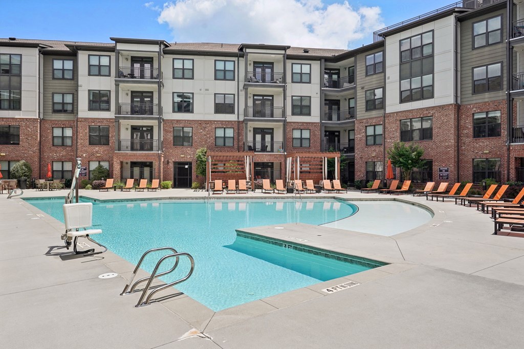 A large swimming pool in front of apartment buildings.